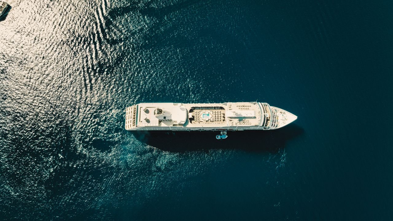 A stunning aerial view of a cruise ship sailing through the deep blue ocean.